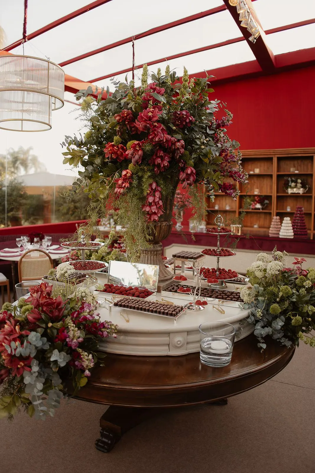 Casamento com arco de vegetação e luzes suspensas ao entardecer