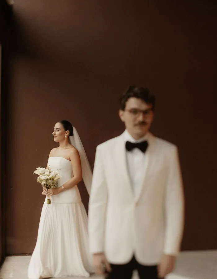 Casal em silhueta a contraluz, refletido na porta de vidro