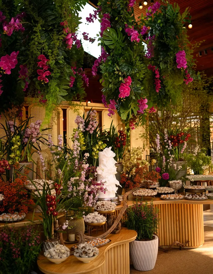 Mesa de doces sob um dossel de flores tropicais